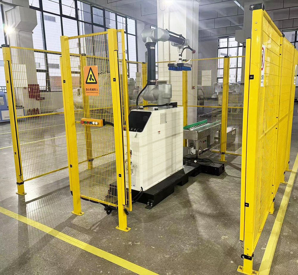 Robot colaborativo de paletizado trabajando dentro de un vallado de seguridad en planta industrial.